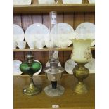 A Victorian brass oil lamp with thistle decoration, 32cm high and two other oil lamps (3)