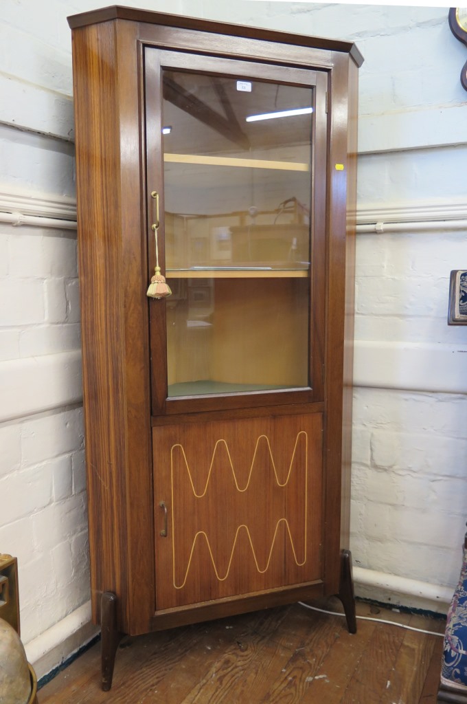 A 1960's rosewood corner display cabinet, the glazed door over an inlaid cupboard door, on moulded