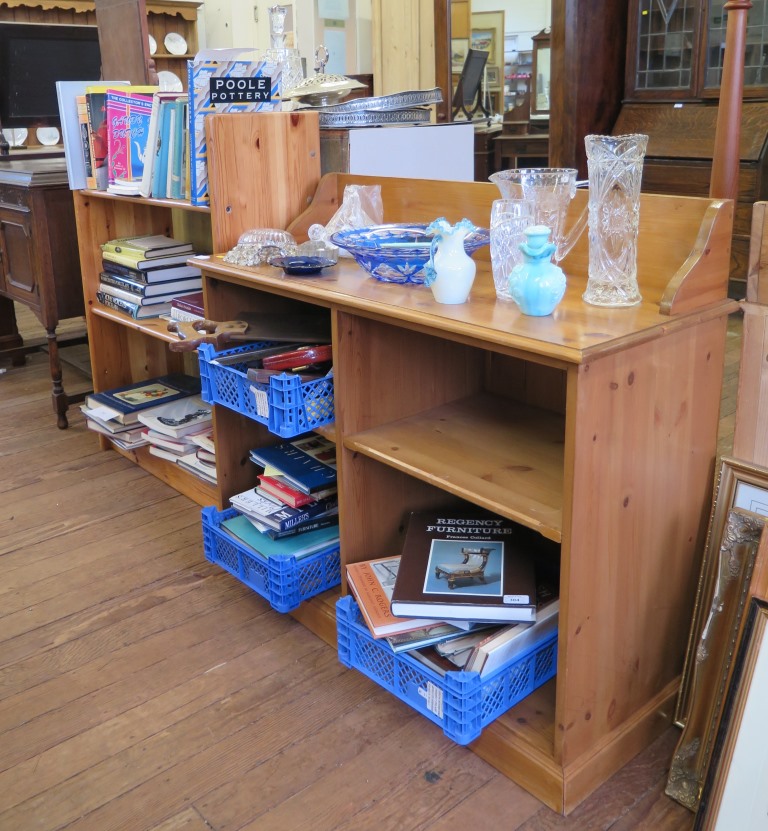 A pine side cabinet with raised back above open bookshelves, 127cm wide, 86cm high together with a