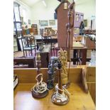 An Eastern wood carving of a chair, two African carvings, two turned wood table lamps and a standard