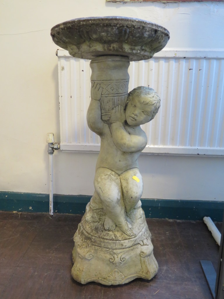 A composite bird bath in the form of a putti holding a vase 76cm high