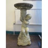 A composite bird bath in the form of a putti holding a vase 76cm high