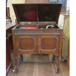 An oak cased Maxitone gramophone with fluted frieze panelled doors and turned legs 76cm wide