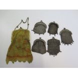 A collection of five Edwardian ladies white metal purses and a gold colour metal purse