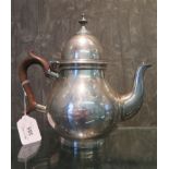 A silver coffee pot of bulbous form having wooden handle and etched coat of arms, by Elkington & Co,