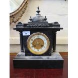 A Victorian slate mantel clock, the domed top over fluted supports enclosing an enamelled chapter