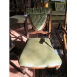 A Victorian walnut fireside chair, the button upholstered open back on ring turned legs and castors
