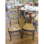 A pair of black lacquered Victorian balloon back chairs, with mother of pearl inlay, cane seat and