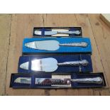 Two silver handled cake server knives with one silver handled boxed butter knife and one silver