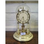 A brass and cream painted anniversary clock, by Kundo, Germany, with glass dome, 30cm high