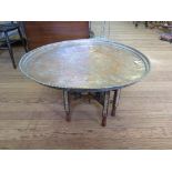 An Iranian silvered copper tray table, on a mosaic inlaid folding base, 80cm diameter