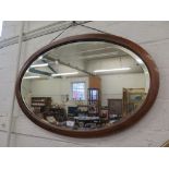 A 1920s mahogany oval wall mirror, with bevelled plate, and chevron banding 83cm x 52cm, and a