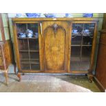 A 1920s walnut display cabinet, the central door flanked by glazed doors, all with applied shell