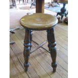 A Victorian turned elm stool, joined by stretchers