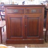 An Edwardian stained beech side cabinet with two short drawers and cupboard doors on a plinth base