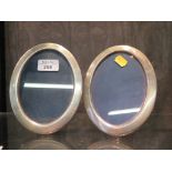 A pair of silver oval photo frames