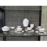 An Art Deco style porcelain coffee service of stepped corical form with silver highlights, six