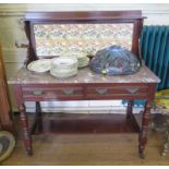 An Edwardian walnut washstand, the tiled back over a marble top with two frieze drawers on ring