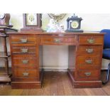 An Edwardian walnut pedestal desk, the leather inset top over three frieze drawers, and pedestals