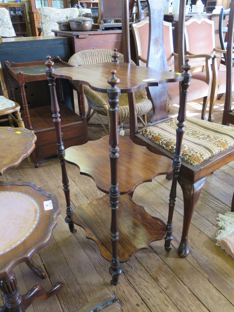 A Victorian rosewood three tier whatnot, with shaped shelves and turned supports on metal casters