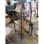 A Victorian rosewood three tier whatnot, with shaped shelves and turned supports on metal casters