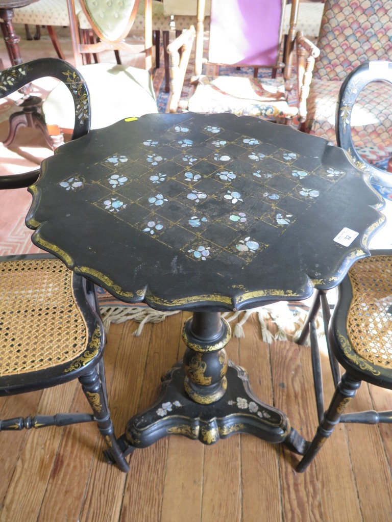 A mid Victorian black lacquered papier mache tripod table, the top inlaid in mother of pearl to form