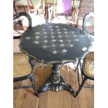 A mid Victorian black lacquered papier mache tripod table, the top inlaid in mother of pearl to form