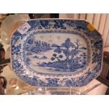 A Chinese blue and white dish, 18th century, depicting a lake scene with oarsmen and houses,