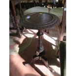 A mid Victorian carved walnut tripod table, the circular top over a carved baluster stem on cabriole