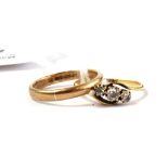 A 9 carat gold wedding ring together with an 18 carat gold diamond three stone cross over ring