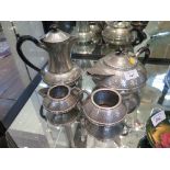 A Sheffield pewter four piece tea service of squat globular form with hammered finish, hot water pot