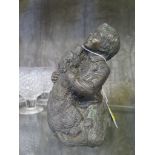 A bronzed finish model of a young boy with his dog trying to lick his face, 15.5cm high