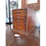 A small wooden chest of six drawers, 26cm high, 19.5cm wide, 31.5cm deep