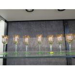 Nine Bohemian green glass wine glasses, with gilded bands to the bowls, and five other drinking
