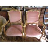 A pair of walnut bedroom armchairs, 1920s, with foliate carved top rails, upholstered backs and