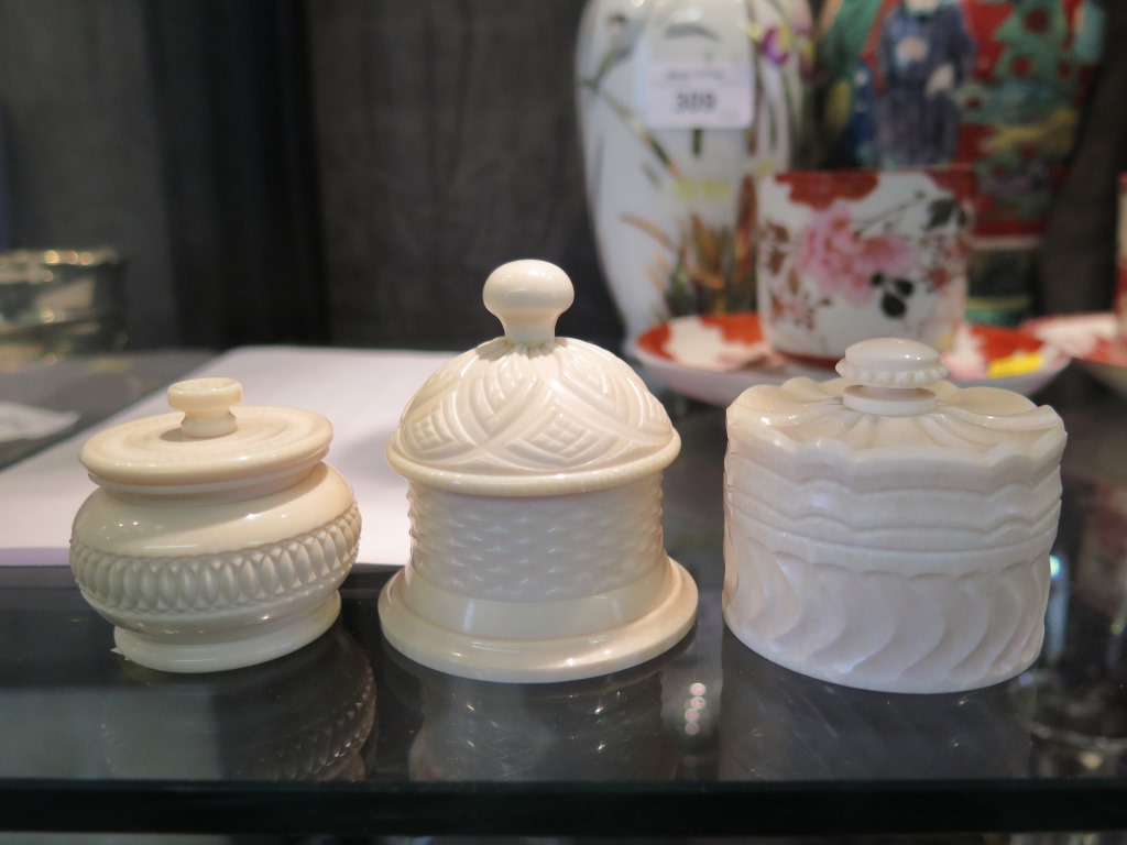 Three engine turned ivory pots, one with fixed lid 5.5cm diameter, the others with threaded lids 4.