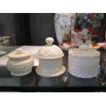 Three engine turned ivory pots, one with fixed lid 5.5cm diameter, the others with threaded lids 4.