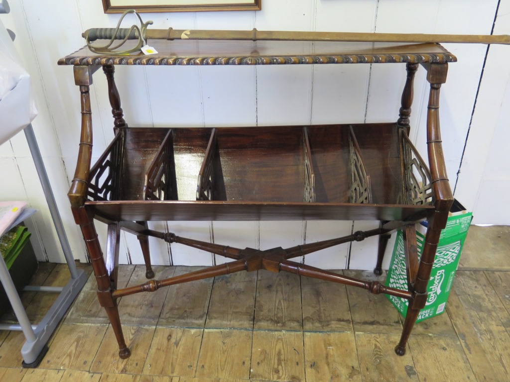 A 1920s mahogany bookrack, the rectangular top with gadrooned edge over an angled book rack with