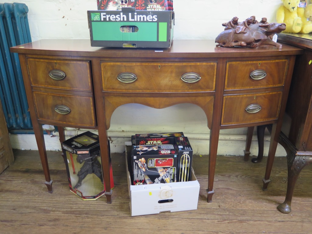 A George III style mahogany and satinwood crossbanded bowfront sideboard, the central drawer flanked