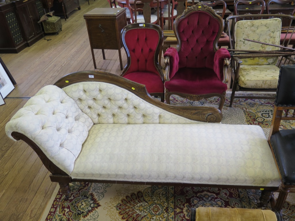 An Edwardian stained beech chaise longue, the scrolling button upholstered back on ring turned