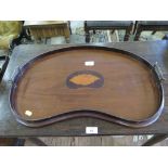 An Edwardian mahogany kidney shaped tray with inlaid shell motif and brass handles, 59cm wide
