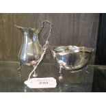 A silver sugar bowl on three pad feet and a matching cream jug, Birmingham 1911/12