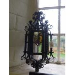 A stained glass and wrought iron lantern, possibly Morroccan, with scrolling decoration, 44cm high