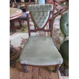 A Victorian walnut fireside chair, the button upholstered open back on ring turned legs and castors