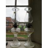 A pair of pressed glass oil lamps, with flying fish motif, 40cm high, (2)