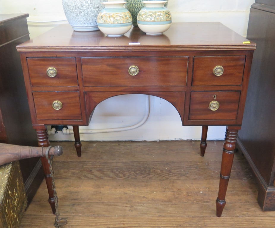 A Regency style mahogany and ebony lined kneehole desk, with false central drawer flanked by two