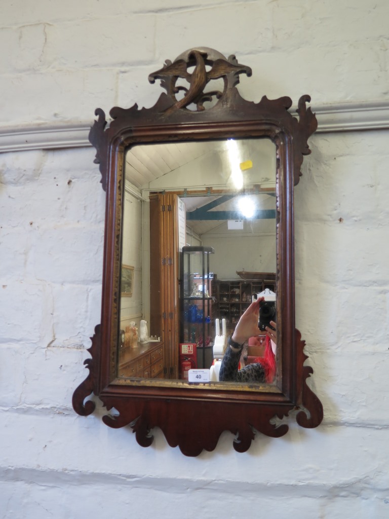 A George III style fret carved mahogany wall mirror, with pierced bird motif over a rectangular