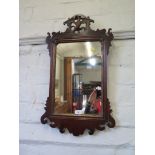 A George III style fret carved mahogany wall mirror, with pierced bird motif over a rectangular