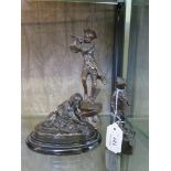 A bronze figure of a boy playing with a cat, on a stone base, 13cm high, another of a piper and a