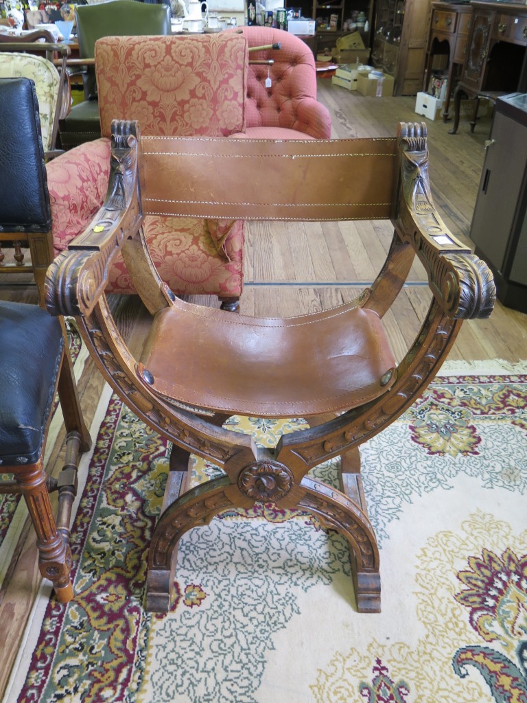 A Spanish style carved crossframe chair, with leather slung back and seat